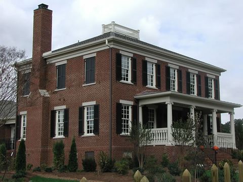 Two-story brick Colonial with dark shutters on every window, the 2004 show home.