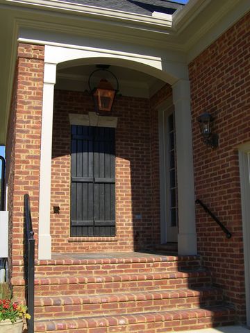 Black board and batten shutters flanking a front entry under the porch, with a faux window.