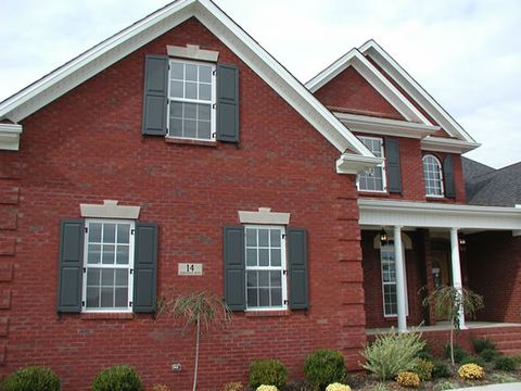 Charcoal flat panel shutters on a red brick gable and front windows, with shutter dogs.