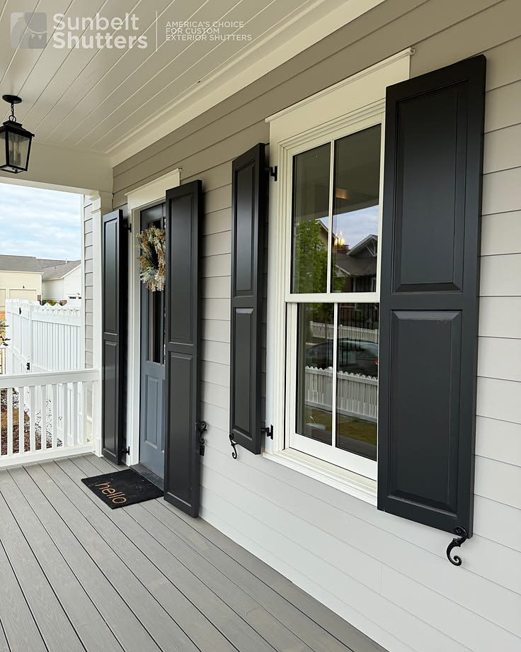 Black raised panel shutters on a covered porch