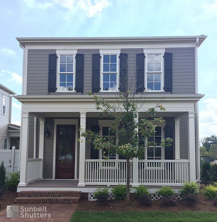 Navy raised panel shutters across the front of a two story home