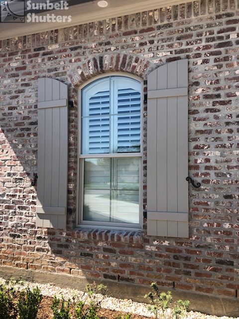 Gray board and batten shutters on a brick home