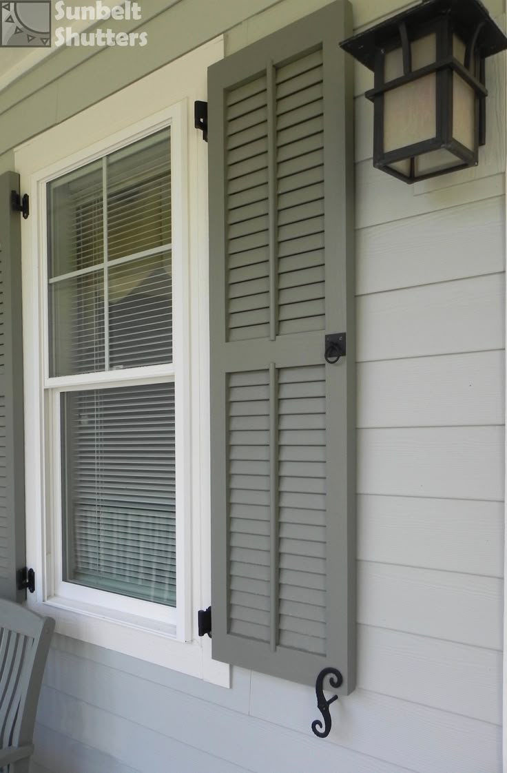 Black plantation louvered shutters on a white two-story home