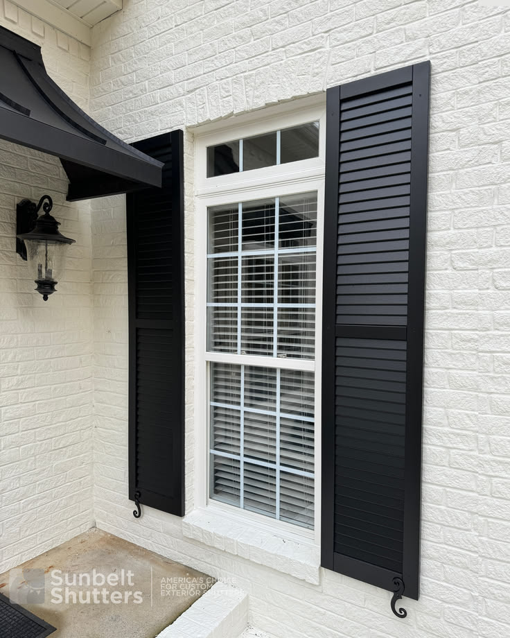 Dark louvered shutters on brick